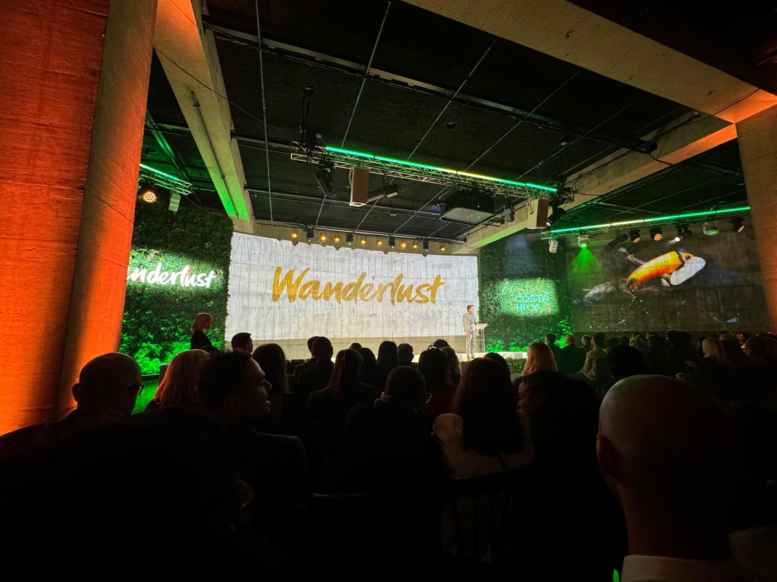 image of people at the Wanderlust awards, with a big screen that reads 'Wanderlust' and a presenter on stage